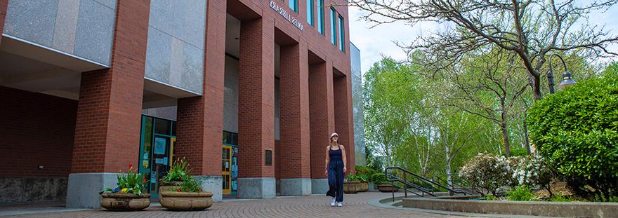 student walking in front of Ames Library